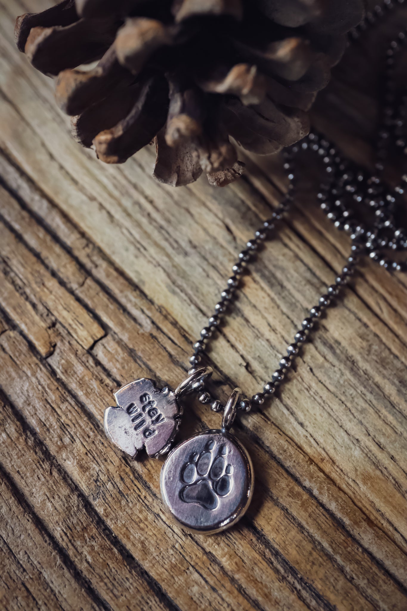 the Stay Wild Wolf Track Necklace (reclaimed sterling silver)